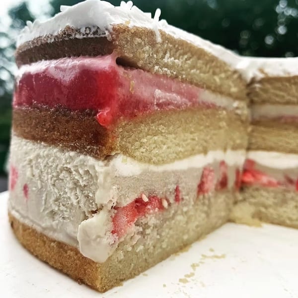 A multi-layered cake with vanilla and chocolate sponge, strawberry jelly, and cream cheese frosting.